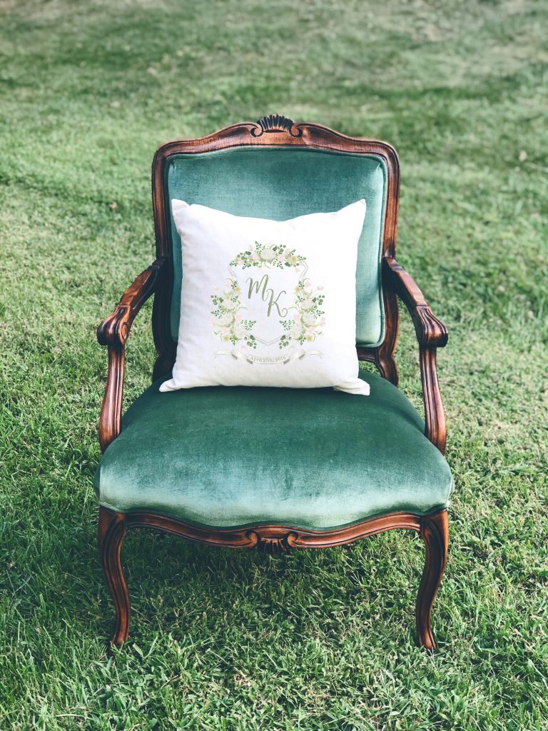 A pillow featuring a watercolor wedding crest by Alicia Betz of The Welcoming District.