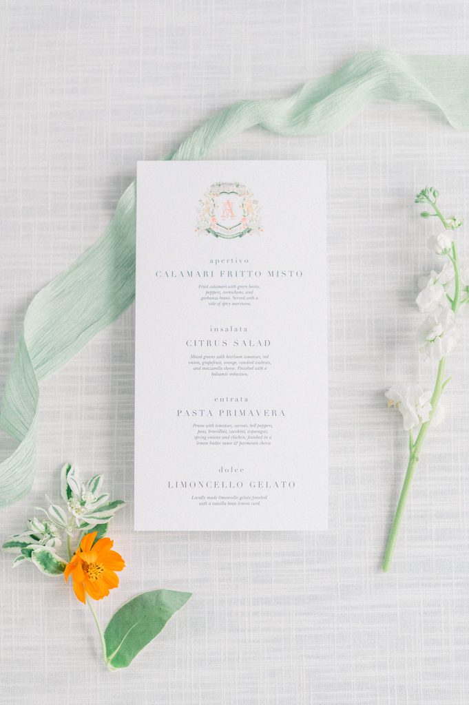 Use your watercolor crest on wedding day details like these beautiful menus at each guests' place setting. Watercolor artistry by The Welcoming District. Visit thewelcomingdistrict.com to get a custom crest for your special day!