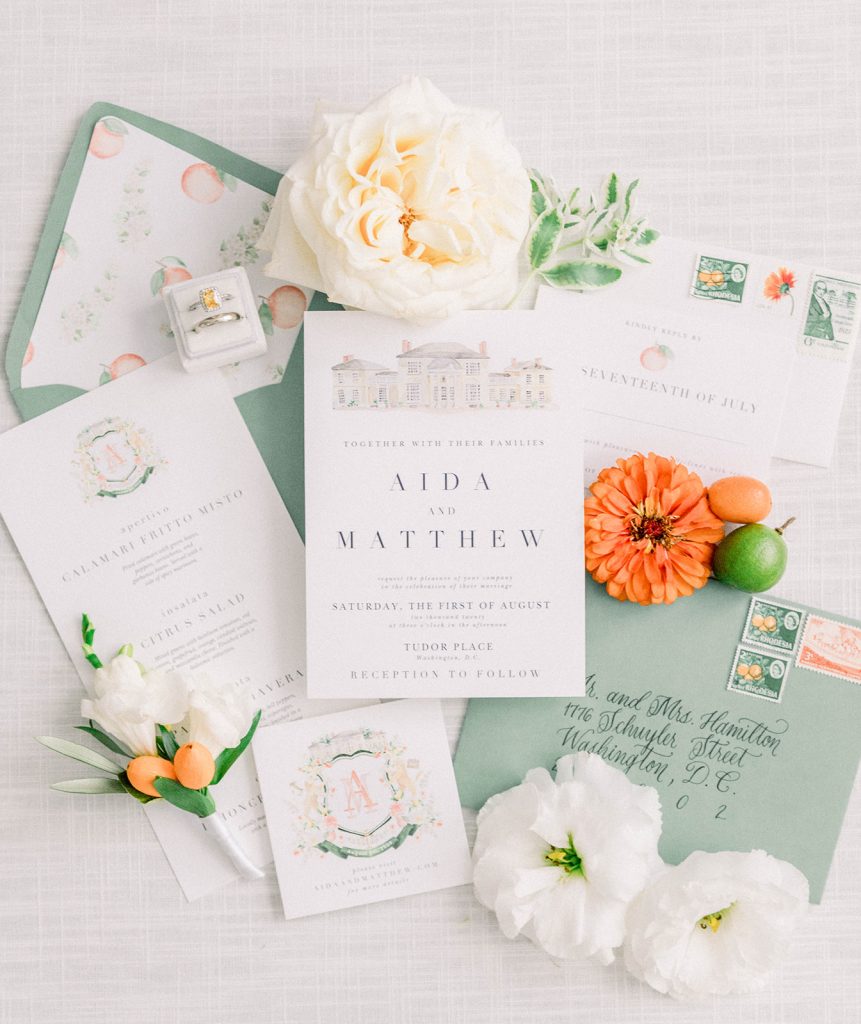 Watercolor wedding stationery by The Welcoming District includes a custom watercolor crest and painting of Tudor Place in Washington, D.C.