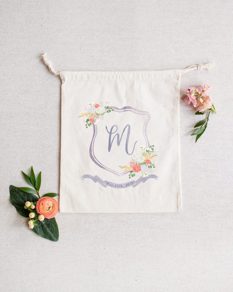 A wedding welcome gift bag featuring a custom watercolor crest by Alicia Betz of The Welcoming District.